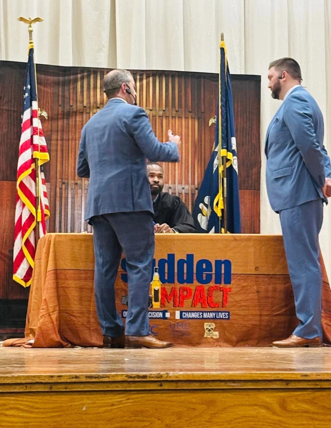 Stephen Spurgeon standing before the judge's bench during a Sudden Impact mock trial on stage